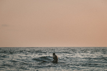 photography of surfer in the middle of the sea thumbnail