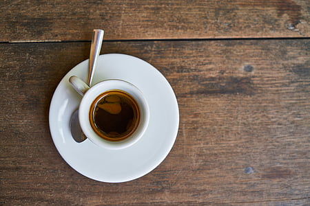 white ceramic coffee cup on brown wooden table thumbnail