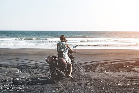 Woman Riding Motor Scooter on Seashore thumbnail