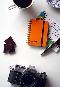 orange spiral book on white wooden table thumbnail