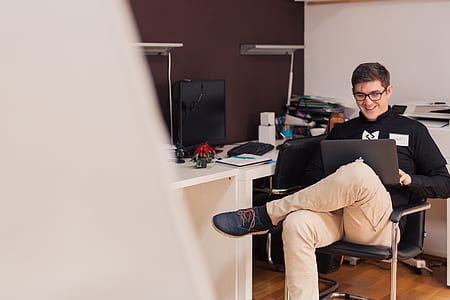 man sitting on armchair using laptop thumbnail
