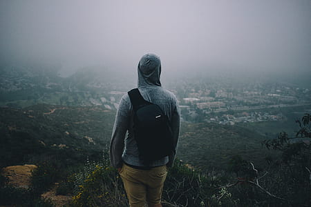man in gray pullover hoodie on hill top during fog thumbnail