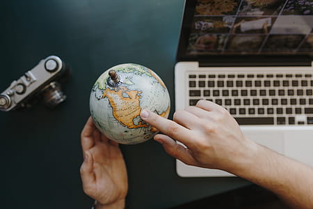 Male Finger Showing A Part Of The World On An Globe thumbnail