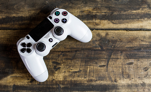 top-view angle photo of PS4 DualShock controller on beige surface thumbnail