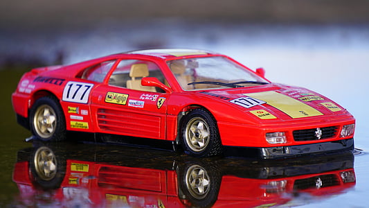 red Ferrari Testarossa scale model toy on mirror surface thumbnail