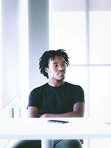 man sitting on chair near white table thumbnail