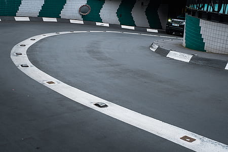 black vehicle traveling on black top road thumbnail