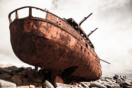 brown sailing ship on rock formation under cloudy sky thumbnail