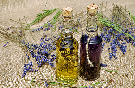 two clear glass labeled bottle near purple petaled flower thumbnail