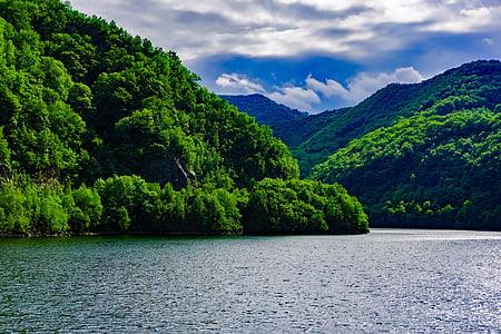 green mountain near body of water during daytime thumbnail