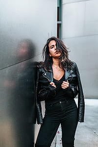woman in black leather jacket leaning on wall thumbnail