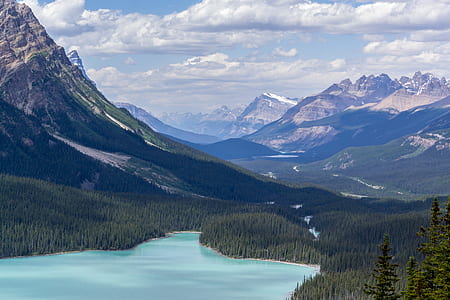 aerial photography of mountain and river under blue sky and white clouds view thumbnail