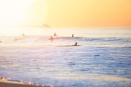 person on surfboard on blue salt water taken at sunset thumbnail