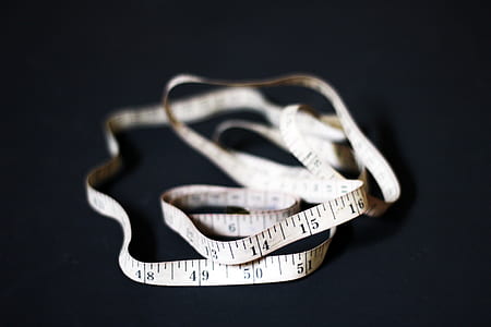 selective focus of white and black tape measure on black surface thumbnail