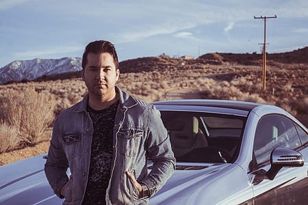 man leaning beside silver coupe thumbnail