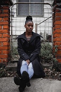 woman wearing black coat sitting near the gate thumbnail