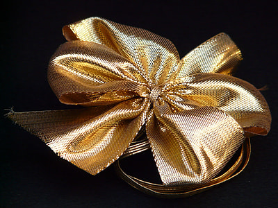 gold-colored bow against black background thumbnail