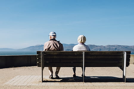 man and woman sitting on bench outdoors thumbnail