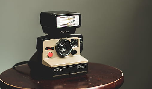 beige and black land camera on top of brown table thumbnail
