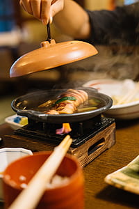 person holding lid of cooking pot thumbnail