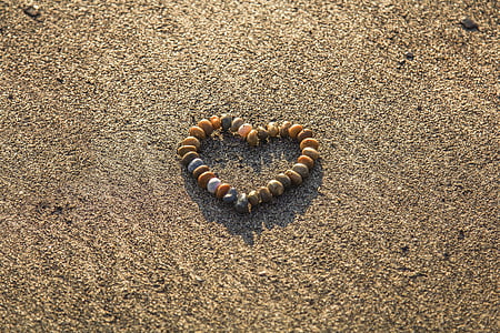 beaded brown, white, and green heart bracelet on gray sand thumbnail