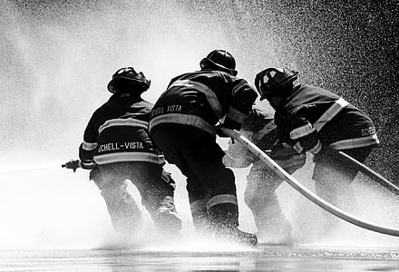 grayscale photo of firefighter holding fire hose thumbnail
