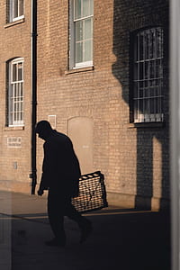 silhouette of man holding rack in alleyway thumbnail
