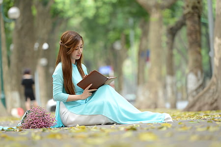 woman reading a brown hardbound book thumbnail