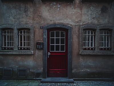 red door on brown house thumbnail