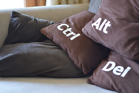 three brown throw pillows on gray sofa thumbnail