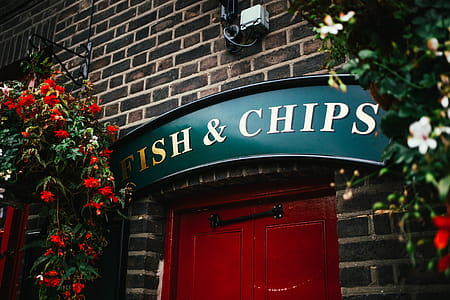 Fish and chips sign at a traditional restaurant entrance in the UK thumbnail