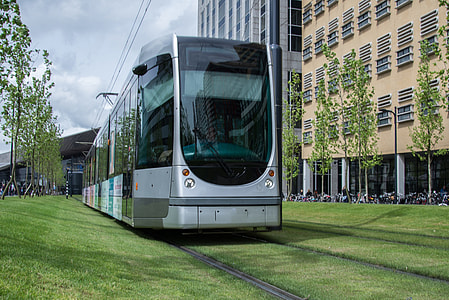 gray train running on green grass field under cumulus clouds thumbnail