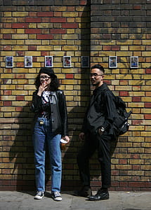 Man and Woman Standing in Front of Concrete Wall thumbnail