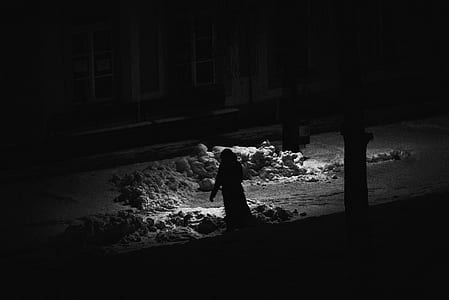 grayscale photo of person walking near house thumbnail