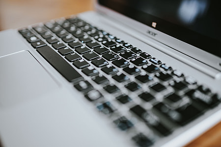 Silver laptop with various items on a table thumbnail