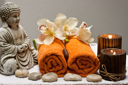 two orange fleece receiving towels beside brown-tinted glass votives thumbnail