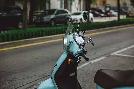 shallow focus photography of teal and black motor scooter thumbnail
