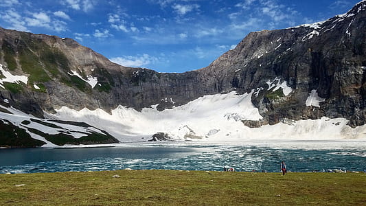 Snow Covered Cliff Near Body of Water Photo thumbnail