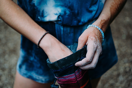 person wearing blue shorts holding black and red pouch thumbnail