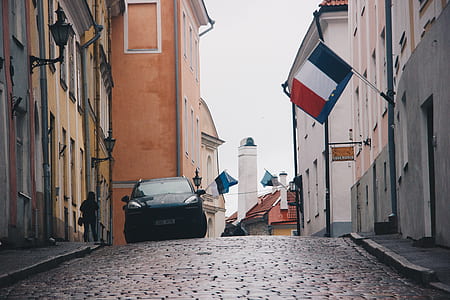 black vehicle parked near street surrounded by buildings during daytime thumbnail