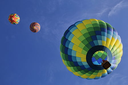 low angle view of three hot air balloons in mid air under blue sky thumbnail