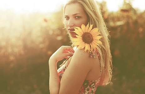 woman holding sunflower during sunset thumbnail