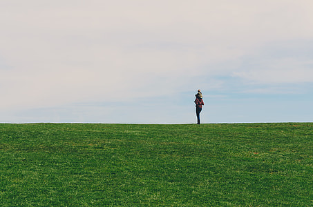 person carrying child on back in green grass field during daytime thumbnail