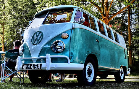 white and gray Volkswagen Kombi near the man sitting on chair thumbnail