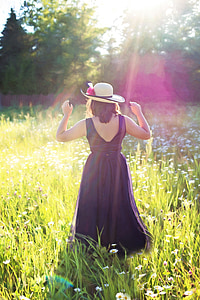 woman in black sleeveless dress walking at the fields thumbnail