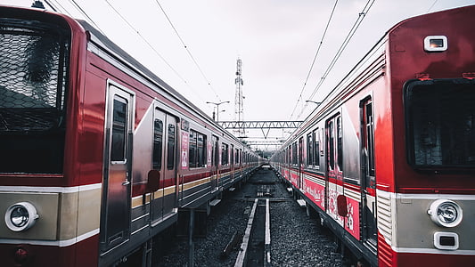 red trains under gray sky at daytime thumbnail