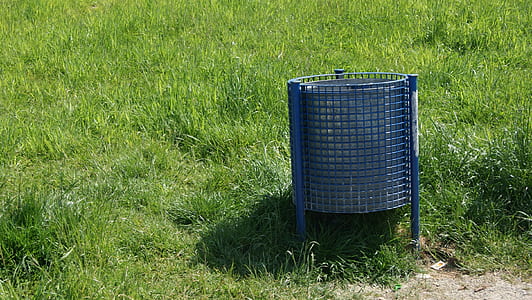 gray metal trash can on grass field thumbnail