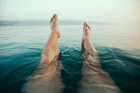 person's feet above water at daytime thumbnail