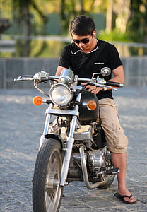 man wearing black T-shirt and khaki cargo shorts riding on motorcycle thumbnail
