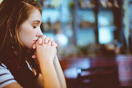 woman wearing white and black top praying thumbnail